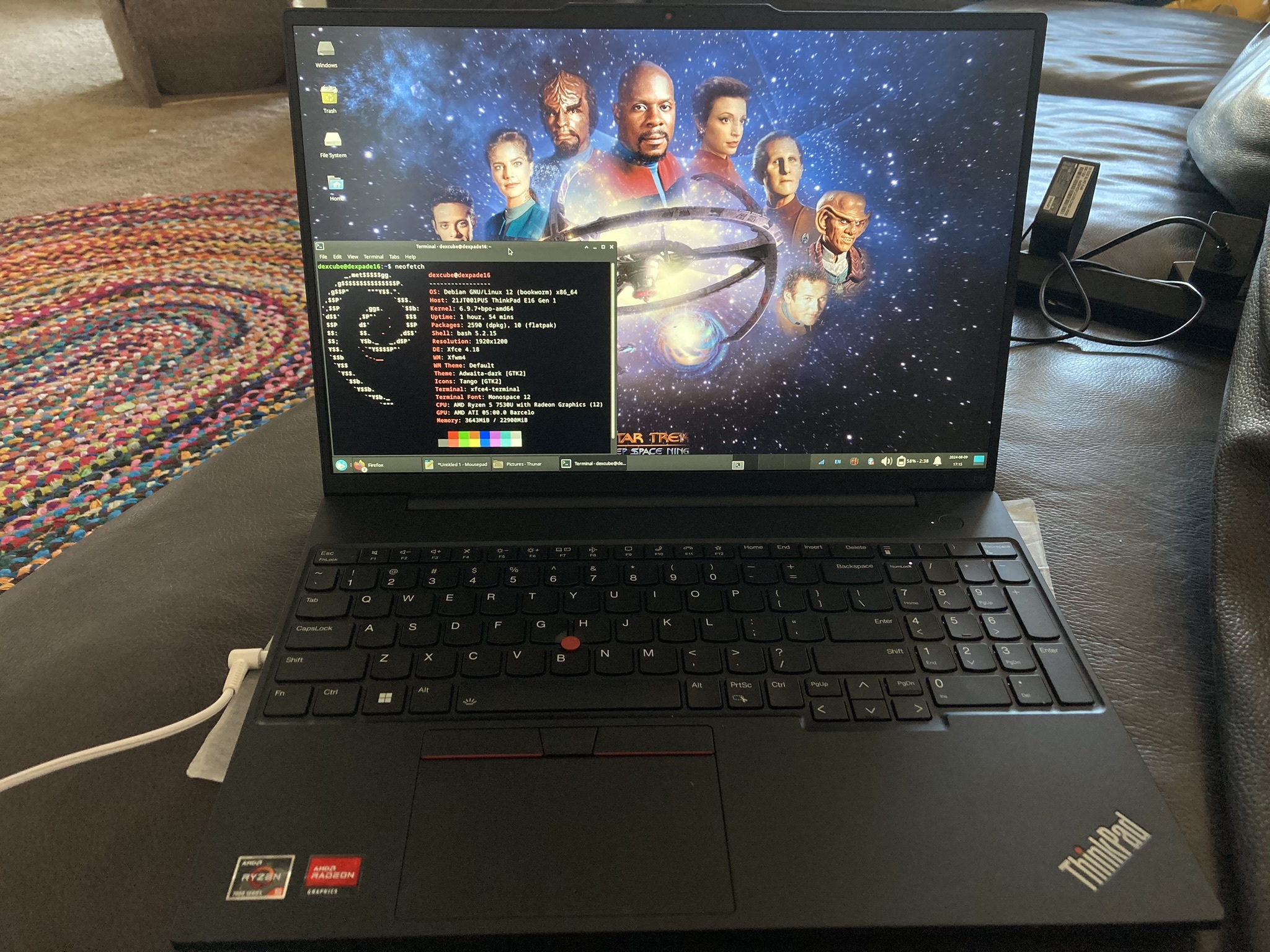 AMD Thinkpad E16 with headphone plugged in. On the screen is Debian 12 Bookworm running on a backports kernel. The desktop background shows characters from the science fiction series Star Trek: Deep SpaceN Nine.