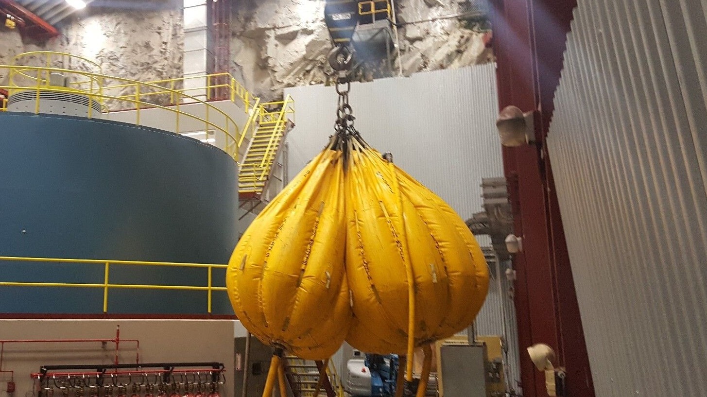 Some big industrial sacks of some kind that look like gigantic truck nutz when suspended from a crane and full of whatever they are full of.