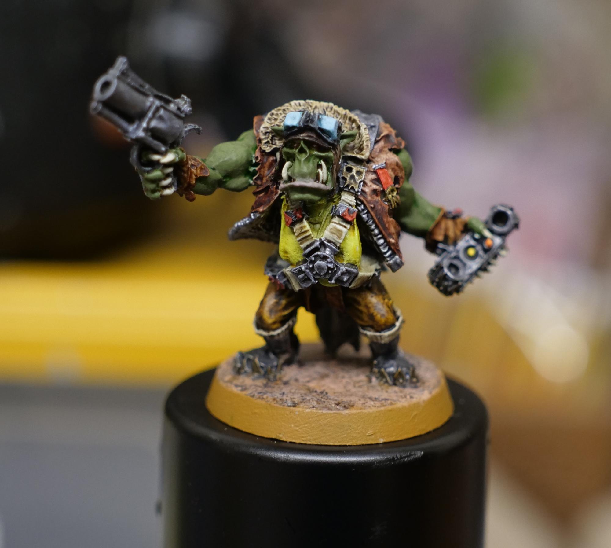 A single painted miniature - a downed Ork pilot. He's holding a revolver in one hand and some sort of radio handset in the other. His clothing is WW2 airman inspired.